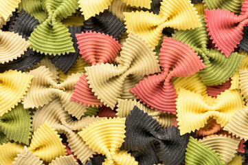 Colored bow tie pasta. Closeup multiple farfalle on white background.