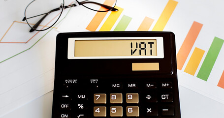 calculator with the word VAT on the display with chart and glasses