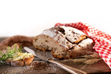 Fresh sliced crusty bread with herb butter
Fresh sliced crusty bread with herb butter and cuminon on rustic wooden table. Close-up with short depth of field and space for text. Background for a bakery