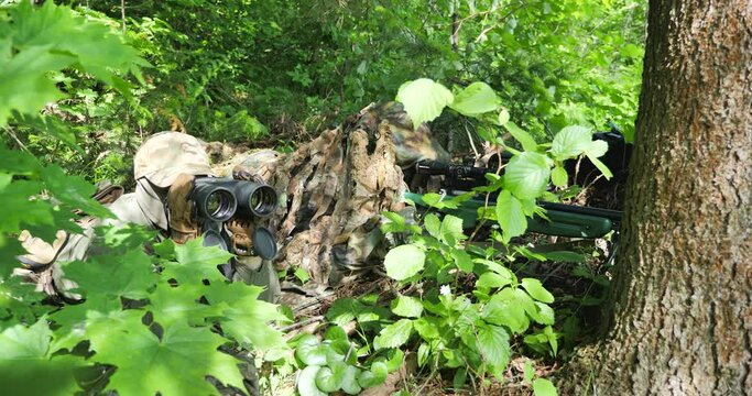 The sniper and the gunner are sitting in ambush, tracking down the target.