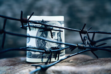 Fototapeta na wymiar Economic warfare, sanctions and embargo busting concept Barbed wire against US Dollar bill.