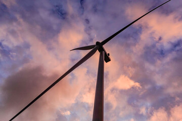 Hirtshals, Denmark A wind turbine view from below and a sunset sky. - obrazy, fototapety, plakaty