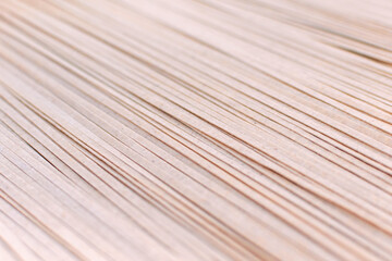 Asian buckwheat pasta, raw, uncooked, dried, natural, organic, vegetarian healthy food. Selective focus background of brown soba noodles close up. Striped surface.