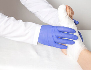 An orthopedic doctor examines a bruised toe. Big toe sprain and fracture concept, close-up,...