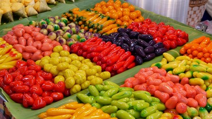 Exotic Oriental Asian sweet delicious desserts, unusual colorful traditional dishes on the counters of a bazar with street food. Evening food court in bangkok, the capital of cooking. Night market.