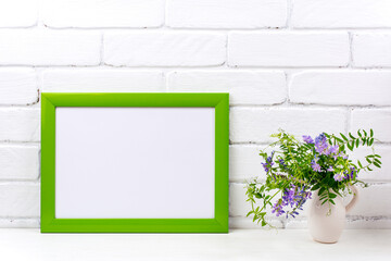 Green landscape frame mockup with purple bird vetch