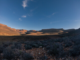 Landscape photograph of the sun settings on a sem-desert mountain