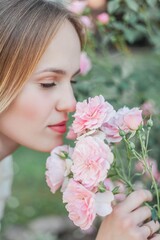 Beautiful young woman in a flower garden. Young beautiful woman portrait. Roses. Summer.
