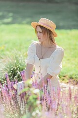 Beautiful young woman in a flower garden. Young beautiful woman portrait. Roses. Summer.
