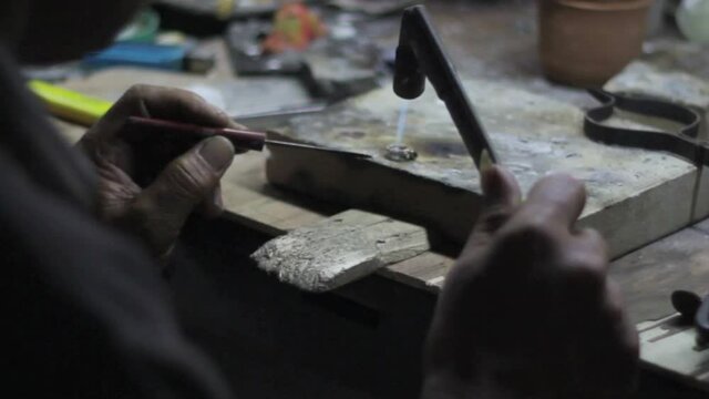 Goldsmith working on his workbench. Production and making manufacturing, factory, cast craft design, process precious gold jewelry, jewels, ring jeweler, goldsmith in workshop.