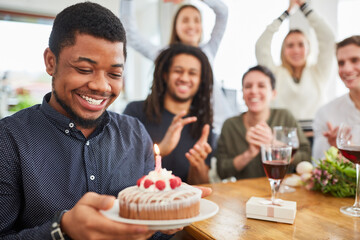 African man with cake and candle at birthday