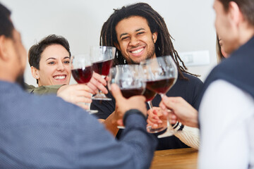 Group of friends toasting with glass of red wine