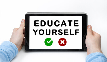 Male hands holding tablet pc with text EDUCATE YOURSELF on white background