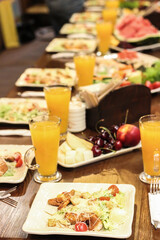 Caesar salad in the restaurant and orange juice. Caesar salad with chicken.