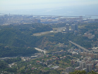 Genova, Italy – 07/30/2020: Beautiful scenic aerial view of the city, port, dam, sea, Cristoforo Colombo airport runway, containers shipping terminal, Pra, Voltri, and Sestri promontory from Monte Gaz
