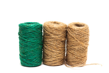 Three skeins of twine. Twine. The twine is brown and green. On a white background, string