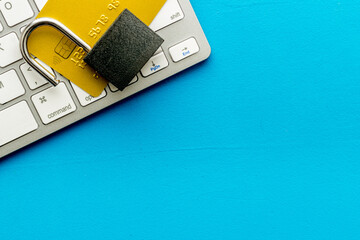 credit card hacked. keyborard, open lock on blue background top view copy space