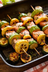 Grilled salmon skewers with zucchini and herb marinade in a grill pan close up view
