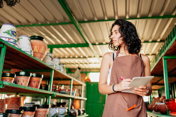 Obraz na płótnie Canvas Young clerk checks the stock in a small ceramic shop