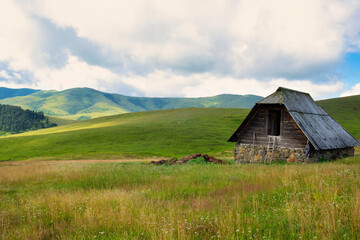 Amazing green field, pastures, mountain road and small farmer hut in the hills of Zlatibor resort in Western Serbia