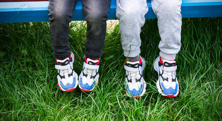  childs sitting together in the same sneakers