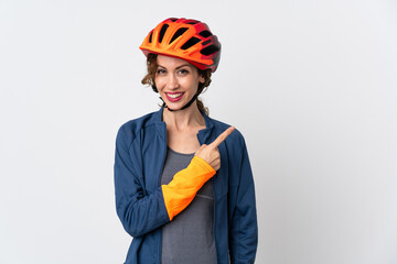 Young cyclist woman isolated on white background pointing to the side to present a product