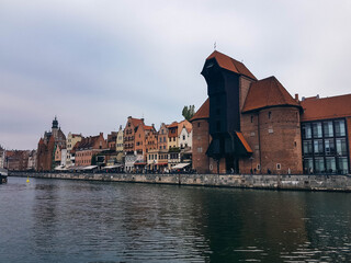 Naklejka premium The main landmark of Gdansk, the Gdansk Crane and houses on the bank of the river Motlawa.