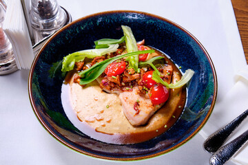 Turkey fillet with chanterelles on a white tablecloth in a restaurant