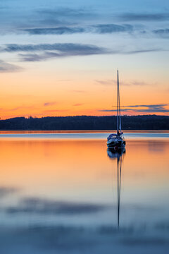 Long exposure image of boat on the calm lake during sunset or sunrise