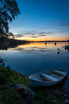 Long exposure image of boat on the calm lake during sunset or sunrise