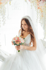 The first meeting of the groom in a black suit and the bride in a white wedding dress with a bouquet in the interior of a photo studio on a white and black background