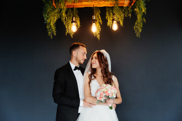 The first meeting of the groom in a black suit and the bride in a white wedding dress with a...