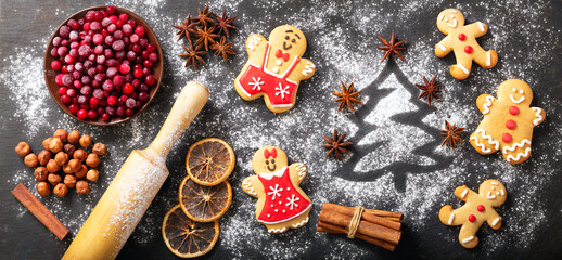 Christmas food. Ingredients for Christmas baking:  fir tree made from flour,  frozen cranberries and gingerbread cookies on dark table