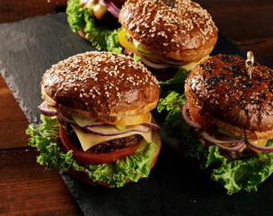 delicious burgers with fried beef cutlet, tomato, lettuce and onions, crispy white wheat flour bun with sesame seeds