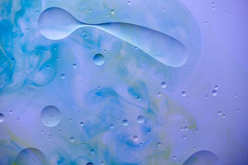 Current collection of brilliant backgrounds for your design. Close-up shot of water spill and drops on painted in blue, violet and green surface.