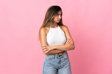 Young caucasian woman isolated on pink background keeping the arms crossed