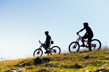 Fototapeta na wymiar silhouette of two young men with mountain bikes