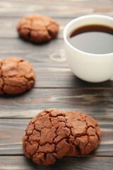 Cup of coffee and chocolate cookies on brown wooden table