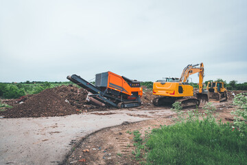 industrial machines clean the landfill and produce fine waste