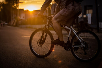 Fototapeta na wymiar A man riding a bicycle with a sunset background.