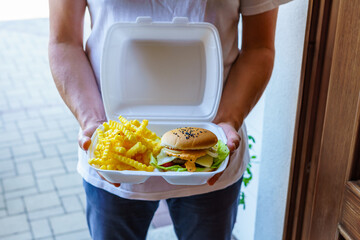 Hauszustellung von frischen Burger und Pommes Frittes in einer Box. Mann, Lieferung, soziale...