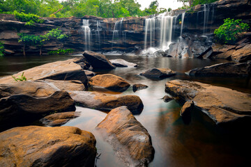 A small waterfall in the deep forest of the border of Thailand and Cambodia,Wang Yai  waterfall in tropical forest,Sisaket province,Thailand. Leaf moving low speed shutter blur.