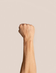 Closeup view of man raising his clenched fist up on light background