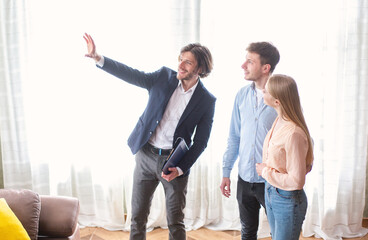 Millennial couple with real estate agent visiting house for sale