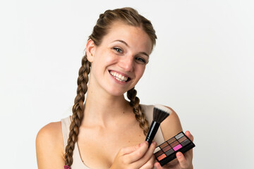 Obraz premium Young caucasian woman isolated on white background with makeup palette and happy