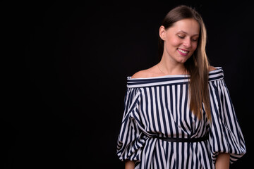 Portrait of young beautiful woman against black background