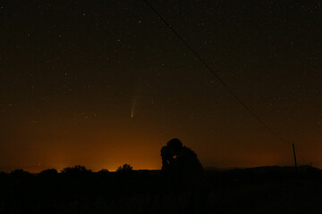 Silhouette of young girl photographing NEOWise Comet
