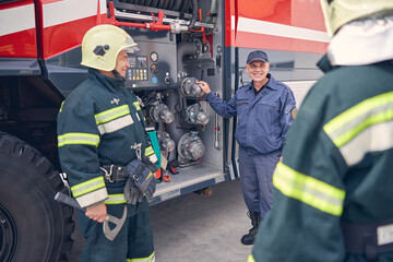 Team building meeting of firefighters near the modern fire truck