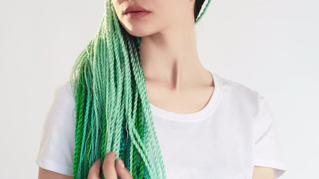Z generation woman with blue green colored hair twist braids isolated on white loop. Ethnic hairstyle. Bright dreads. Professional hairdo. Beauty salon. Creative lifestyle.