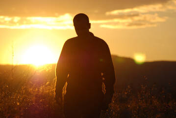 Man walking silhouette in a field at sunset, Catalonia, Spain